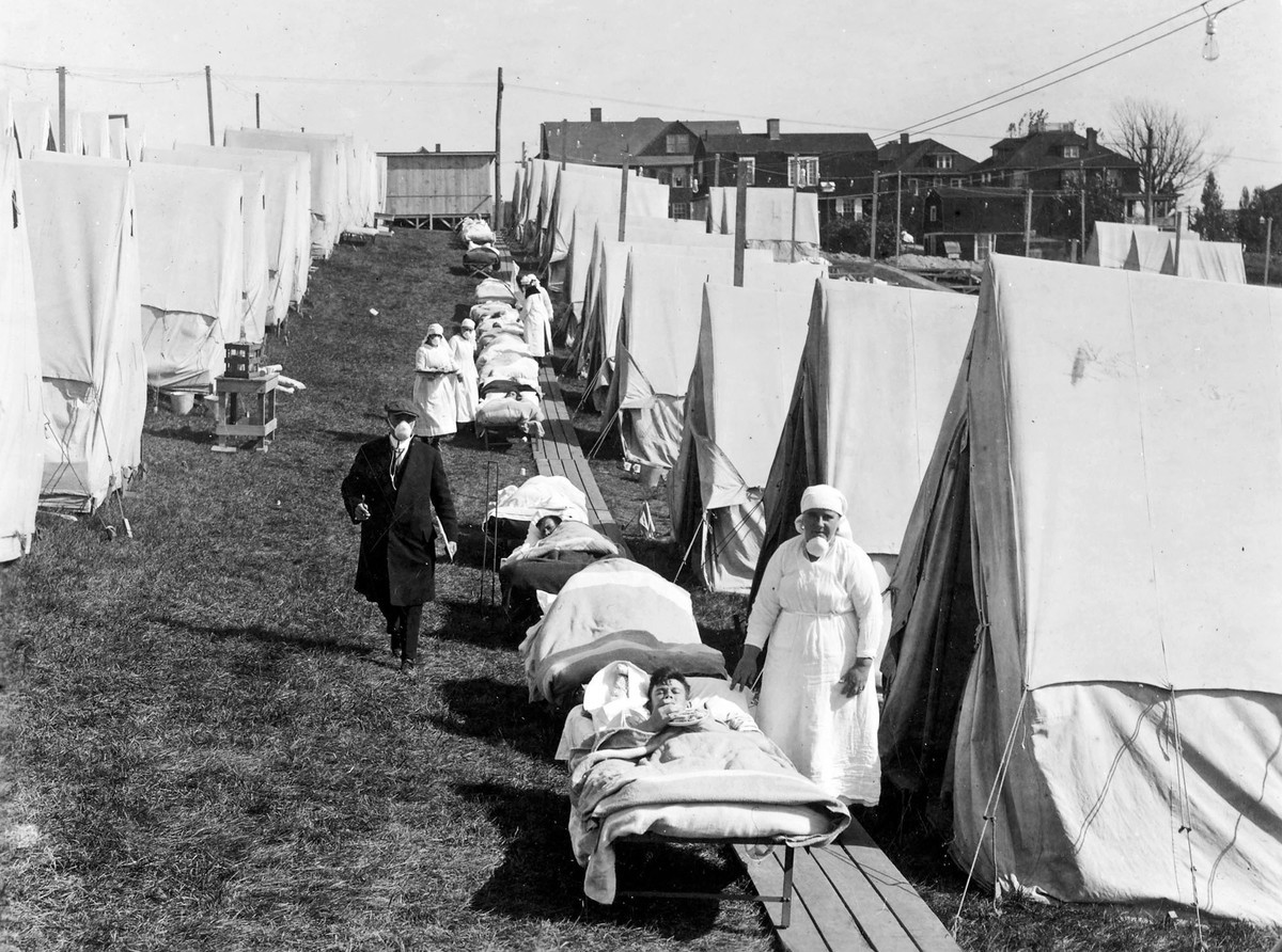 Influenza patients getting sunlight at the Camp Brooks emergency open-air hospital in Boston. Medical staff were not supposed to remove their masks. (National Archives)